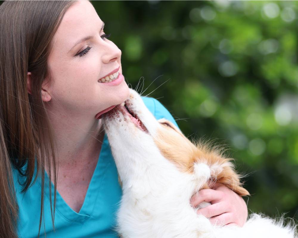 Dog licking woman's face.