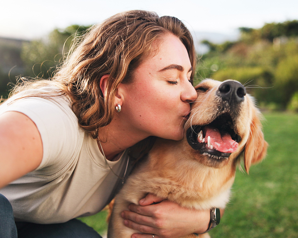 woman embracing her dog outside